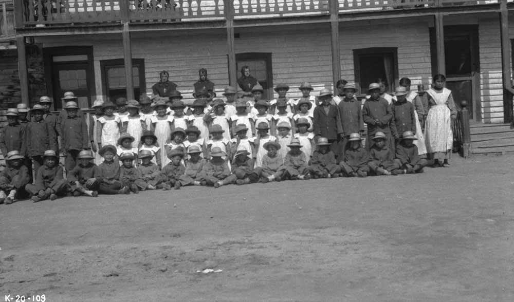 Aboriginal school children outside the Fort Providence Indian Residential School circa 1920. (Photo: F.H. Kitto / Library and Archives Canada / PA-101547)